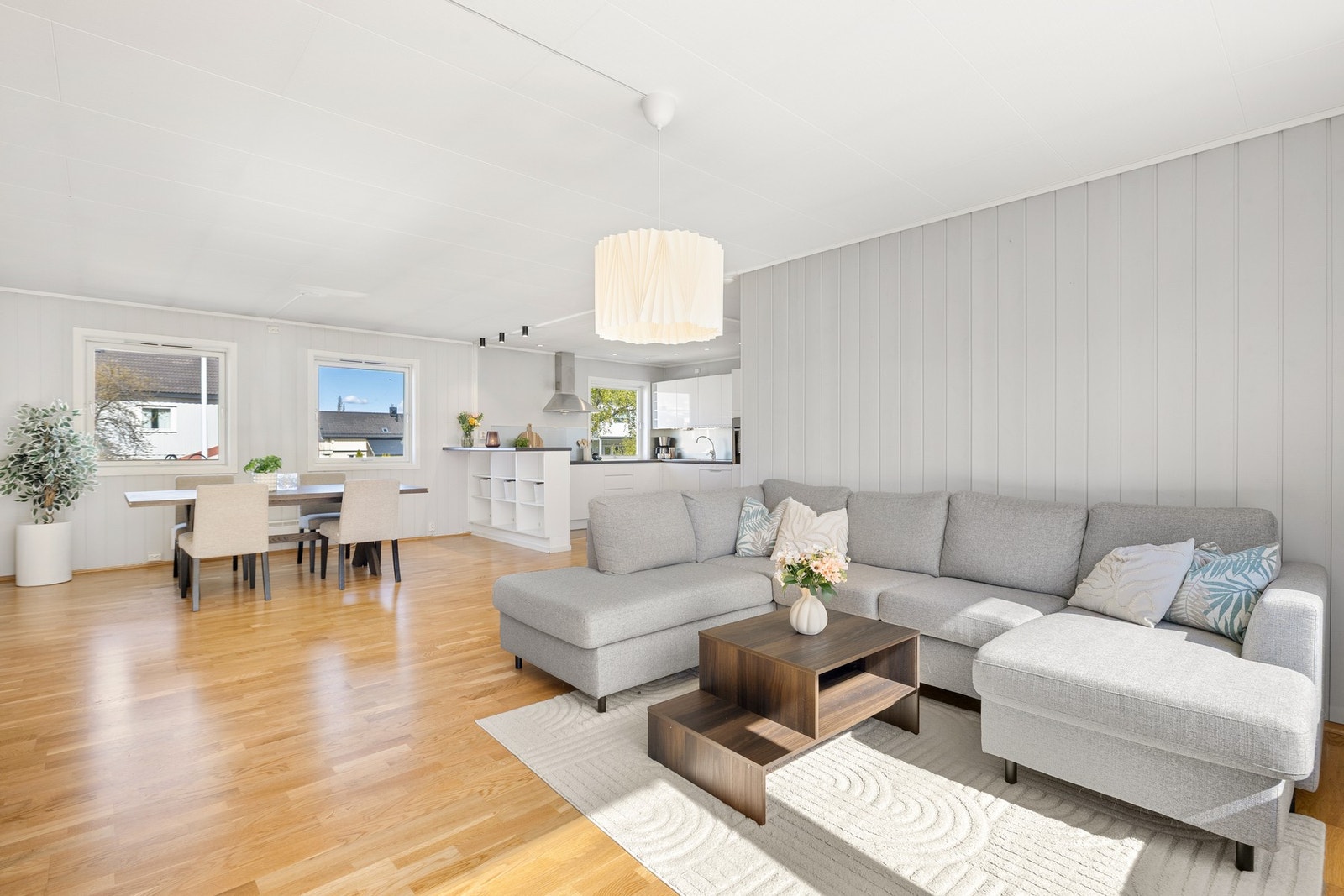 Stuen i utleiedelen fremstår lys og romslig med åpen løsning mot kjøkken og spiseplass. De store vindusflatene slipper inn rikelig med naturlig lys og gir rommet en luftig og innbydende atmosfære. Galleribilde