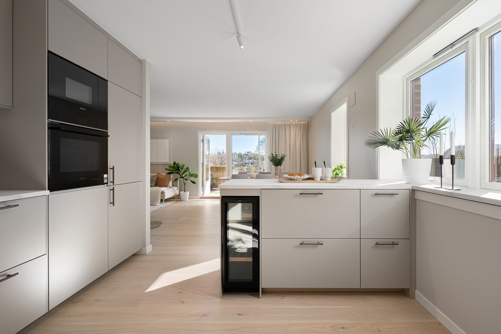 Elegant kjøkken med marmormønstret benkeplate. Bronsefarget, stilrene grep og kvalitetsarmatur fra Tapwell med uttrekkbar tut. Galleribilde