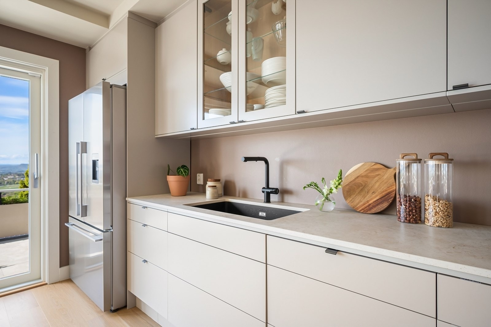 Kjøkkenet er utstyrt med slitesterk keramisk benkeplate, underlimt oppvaskkum og ettgreps blandebatteri fra Franke. Galleribilde