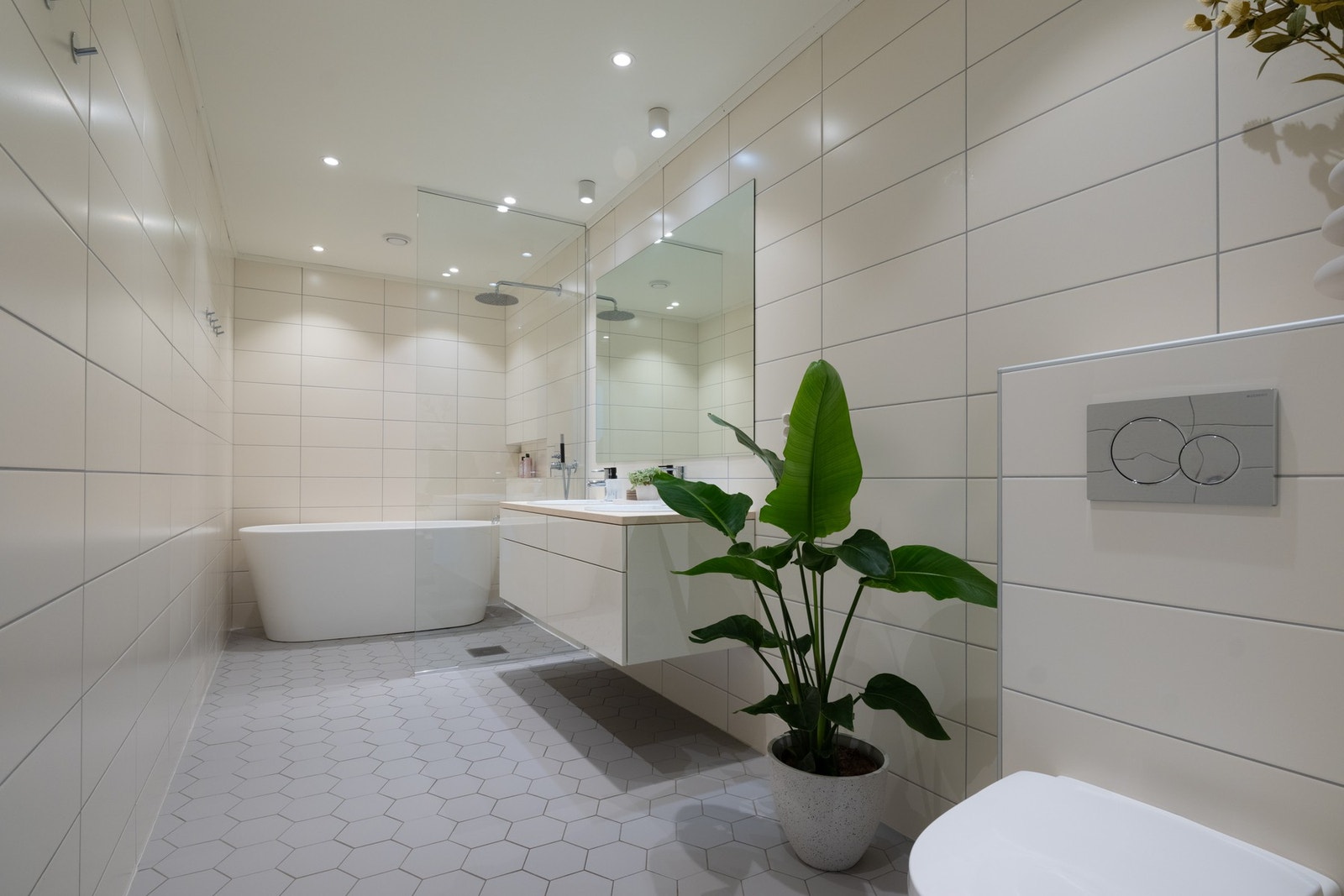 Delikat, romslig baderom med lyse fliser og downlights i himling. Badet har videre gulvvarme. Galleribilde