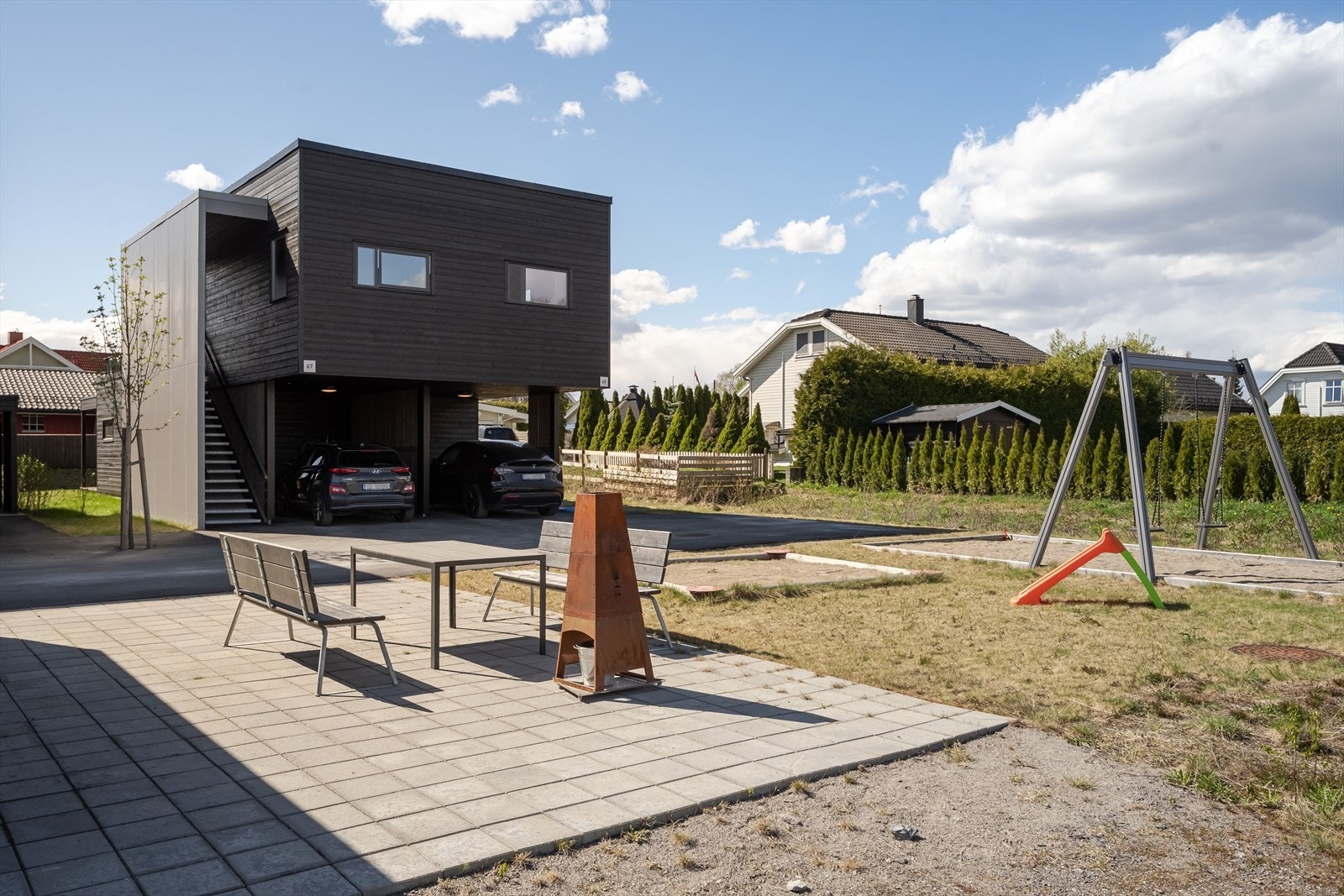 Pent og koselig fellesområde for sameierne med sittebenker, sandkasse og lekeapparater. Galleribilde