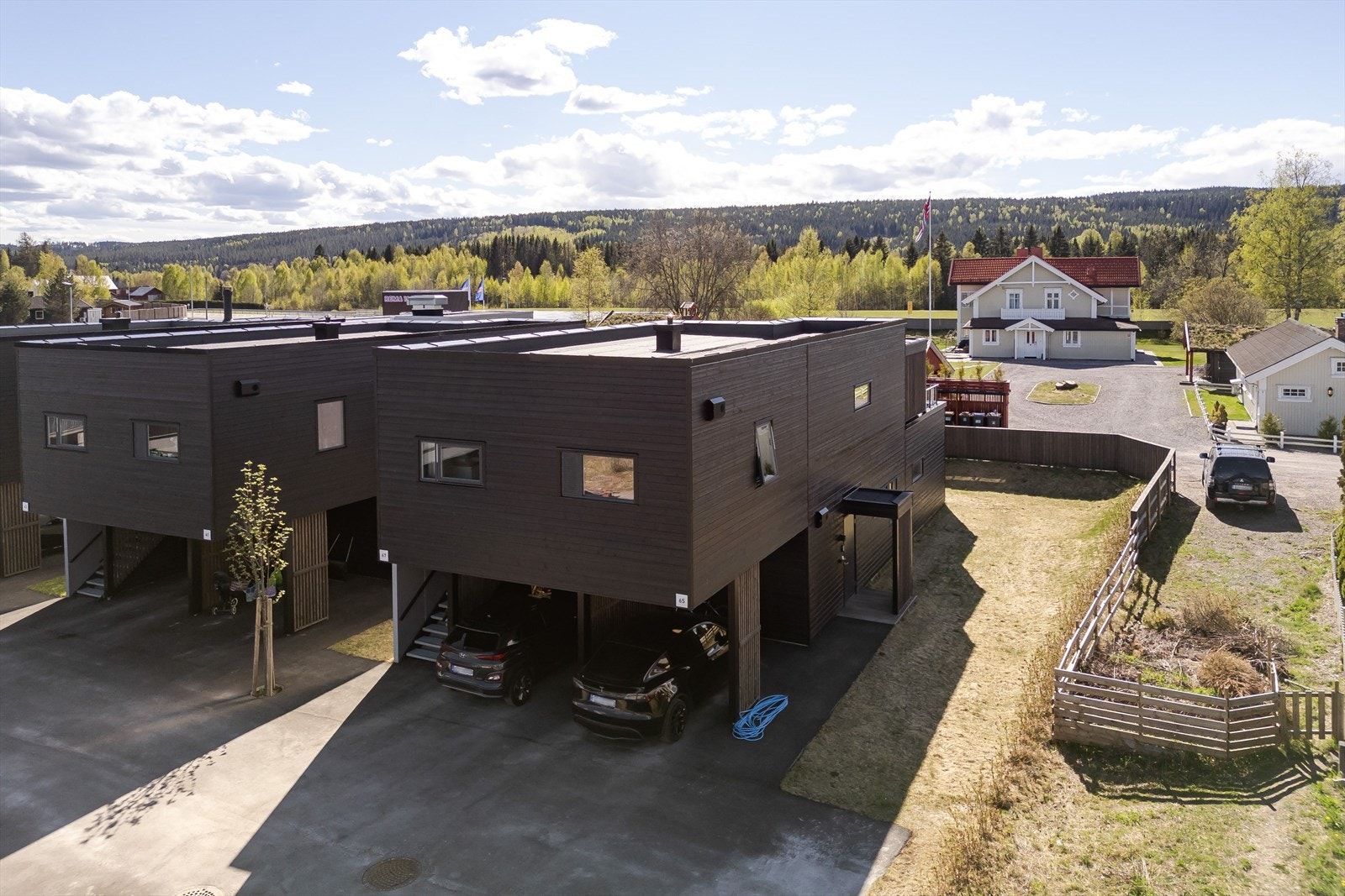 Parkering i inntilbygget carport med elbil-lader. Galleribilde
