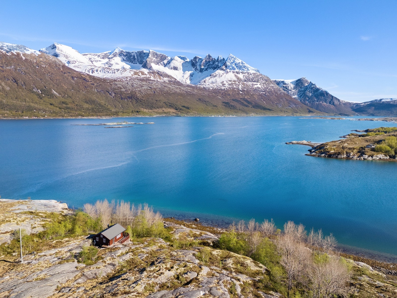 Hytta ligger flott til i terrenget med fantastisk utsikt mot fjord og fjell Galleribilde