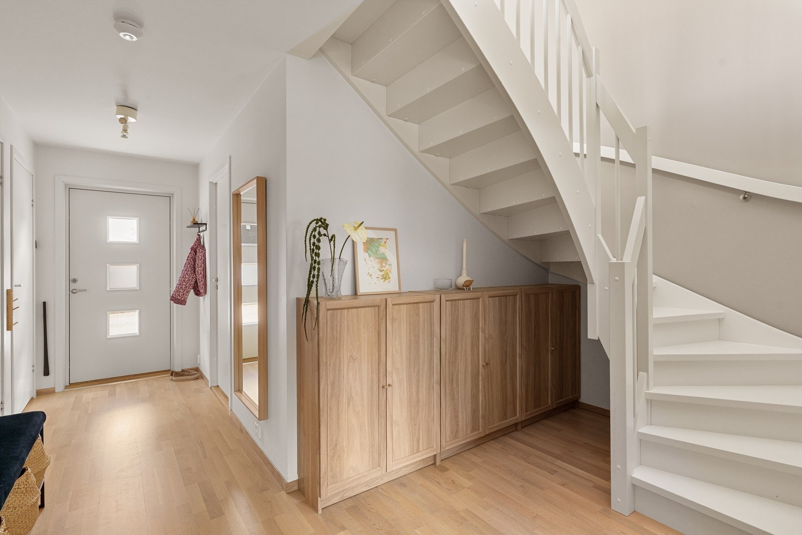 Lys og innbydende entré med plass til oppbevaring og trapp til andre etasje. Galleribilde