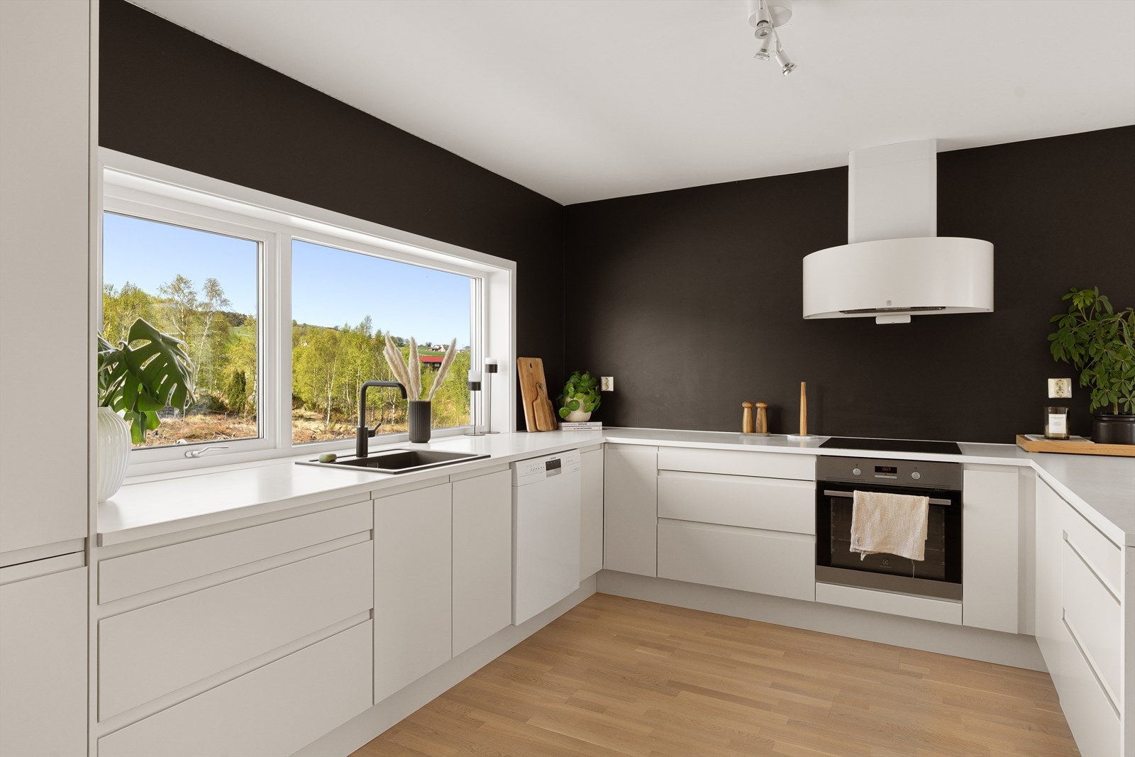 Moderne kjøkkeninnredning med integrert stekeovn, induksjonstopp og kjøl-/fryseskap. Galleribilde