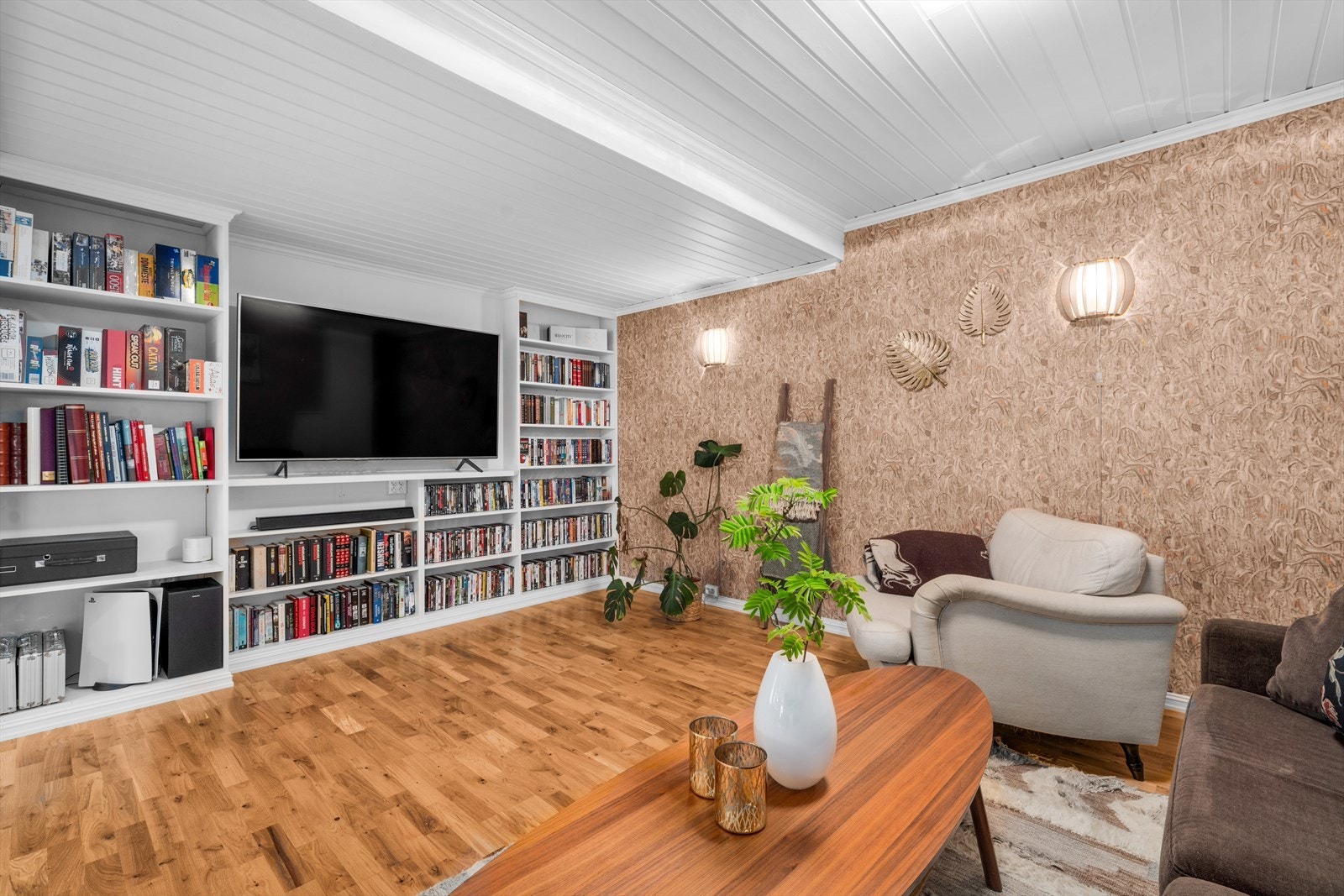 Den ene delen av stuen er innredet som en TV-stue med plassbygde bokhyller. Galleribilde