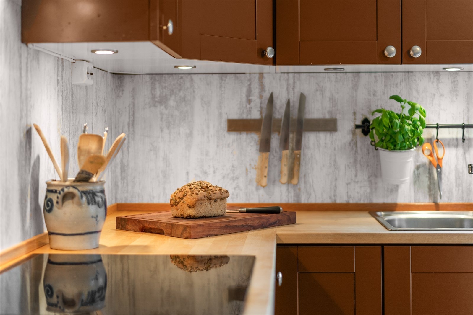 Det er montert kitchenboard mellom benkeplate og overskap som skaper en fin kontrast. Galleribilde
