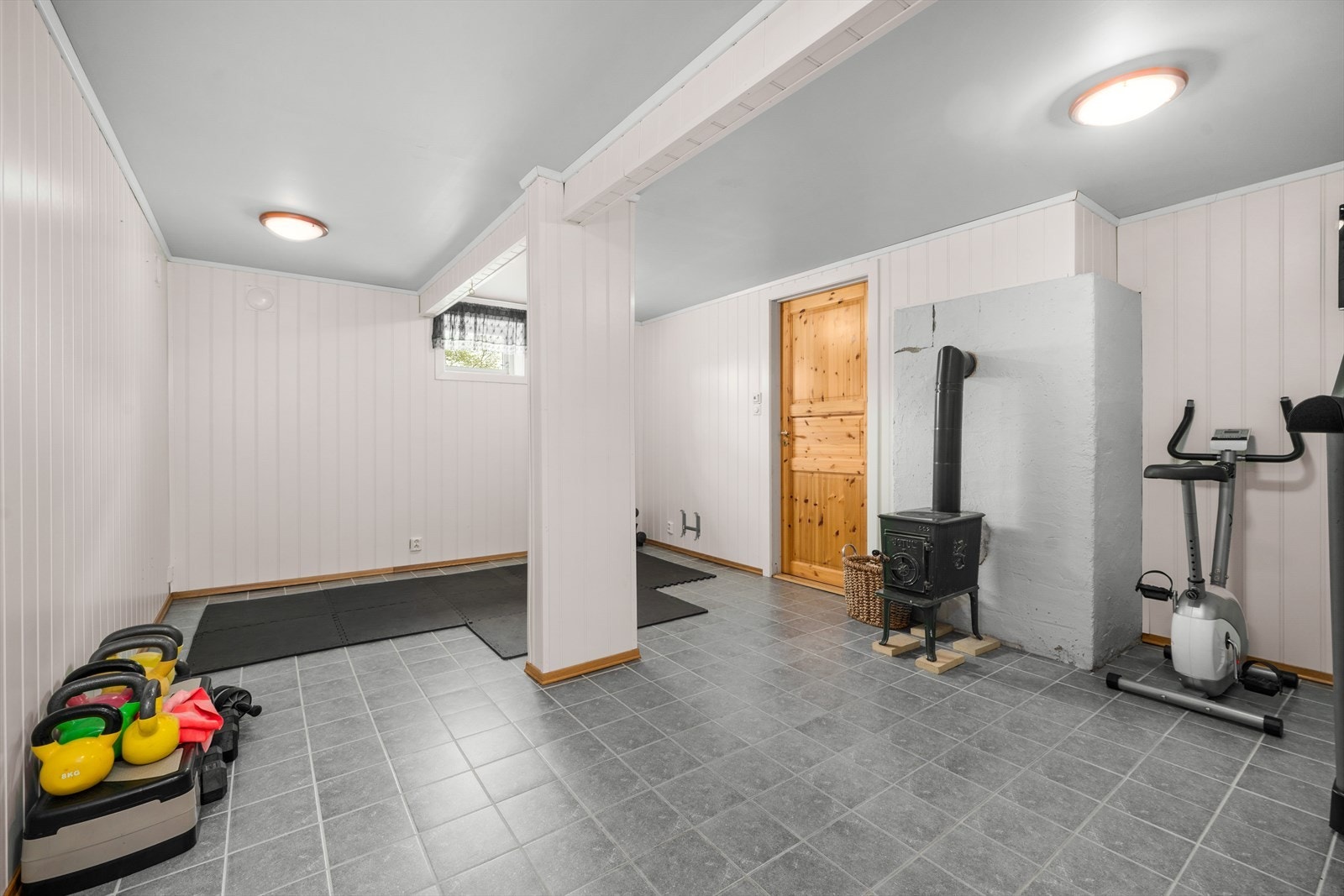 Innredet rom i kjelleren, med panel på vegger og fliser på gulv. Rommet er ikke godkjent for varig opphold. Galleribilde