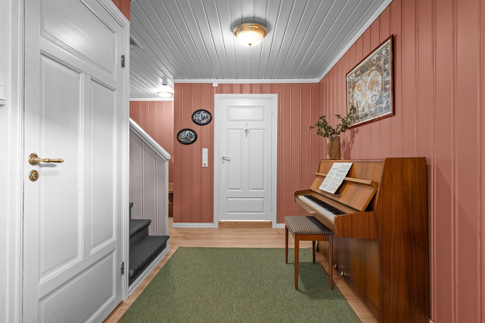 Gangen har panelvegger og et stilrent gulv som går igjen flere steder i boligen. Galleribilde