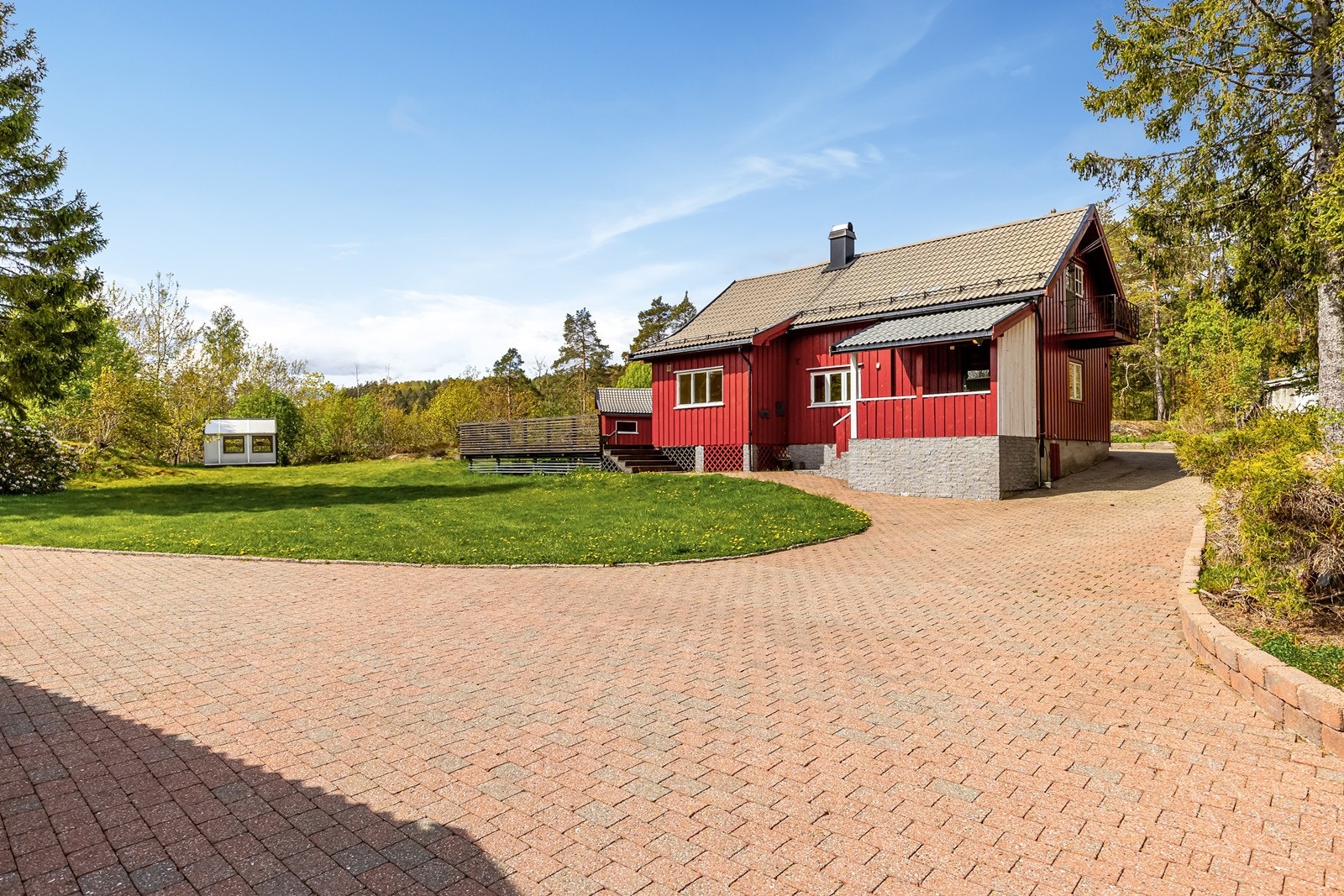 Innbydende tun med belegningsstein og god plass til biloppstilling. Galleribilde