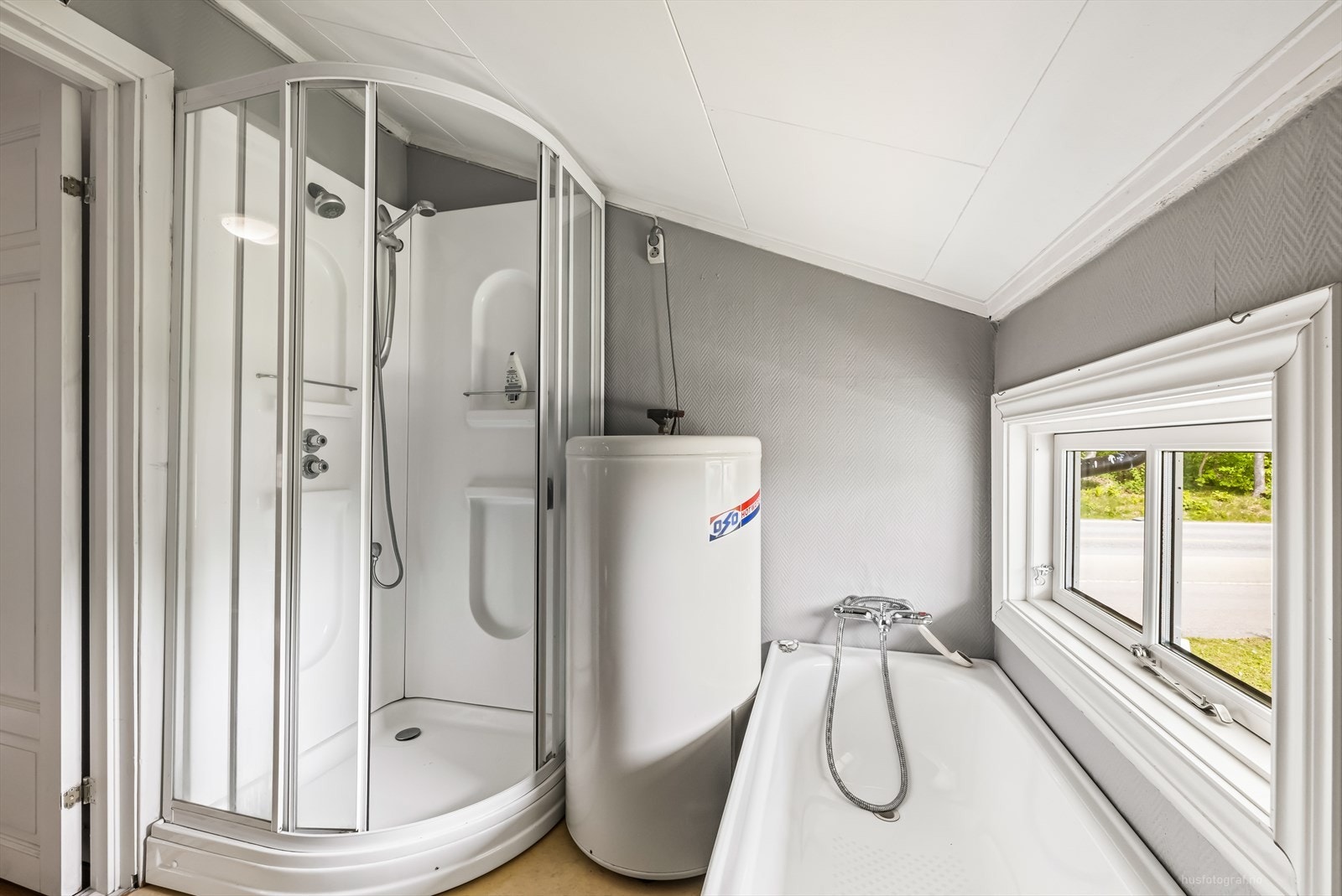 Badet er utstyrt med toalett, dusjkabinett og badekar. Galleribilde