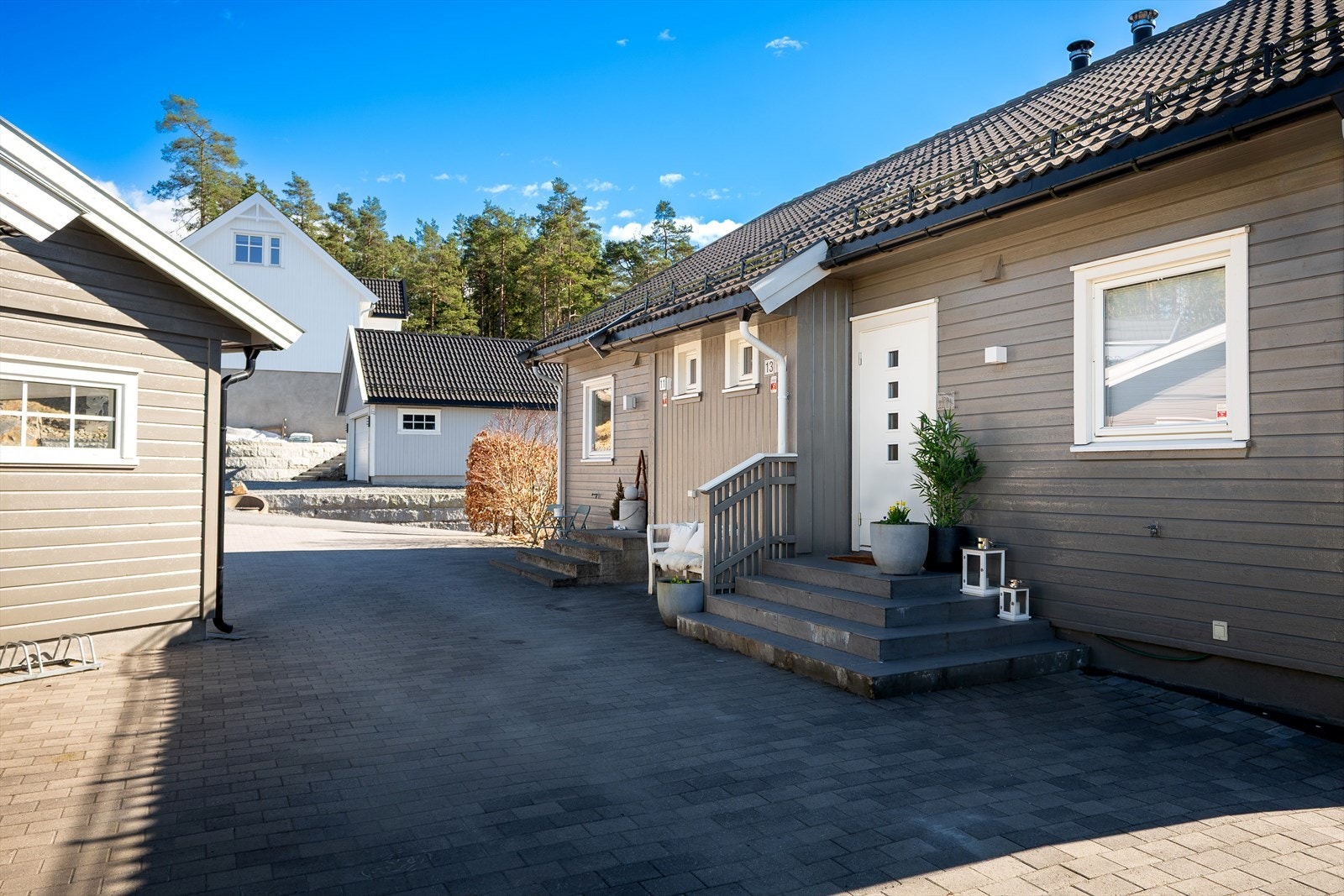 Hyggelig inngangsparti med belegningsstein og trapp opp til boligen. Det er Yale Doorman-lås. Galleribilde