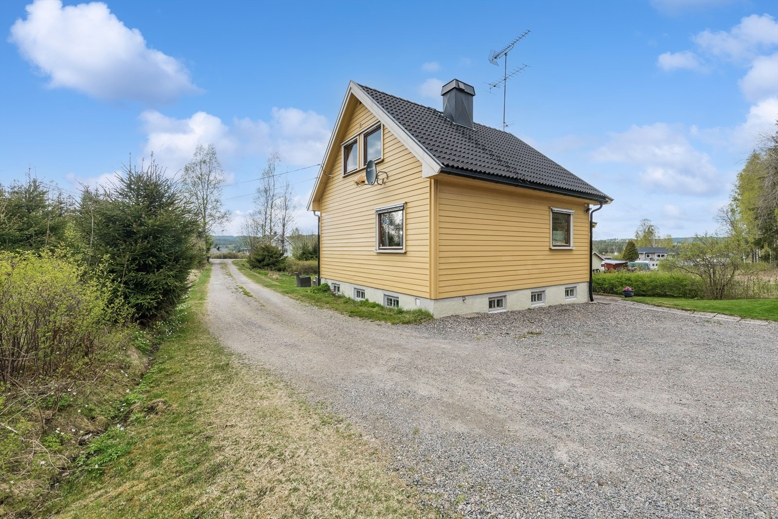 Gruset innkjørsel og gårdsplass med god plass til parkering. Galleribilde