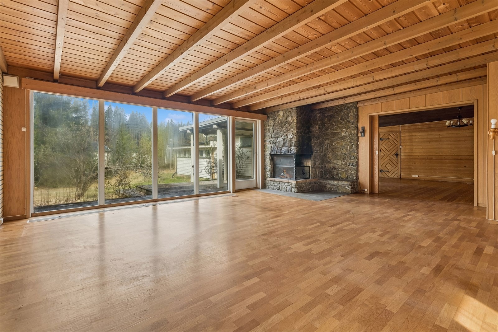 Den ene av boligens to stuer har en stor, murt peis og parkett på gulvet. Galleribilde