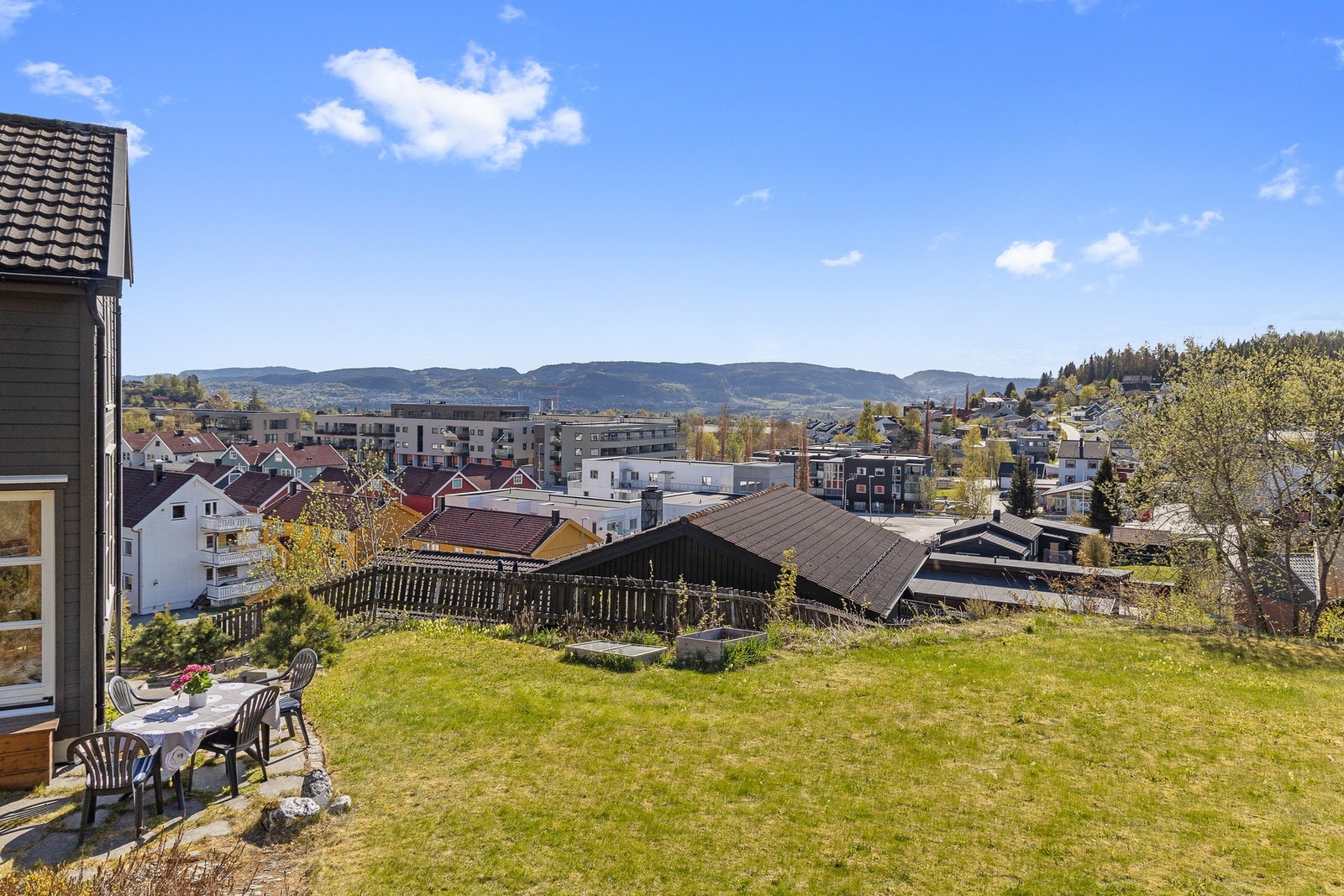 Eiendommen byr på det beste fra to verdener - hellelagt uteplass og en flat, velholdt plen kombinert med en sjarmerende naturtomt. Galleribilde