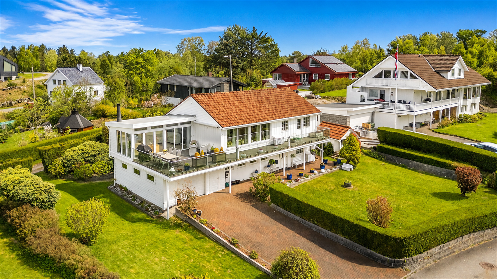 Eneboligen går over to plan med integrert garasje, vinterhage, frittstående utestue og redskapsbod.
Foto: Hanne Tolleshaug Galleribilde