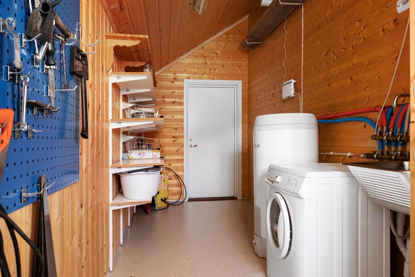 Praktisk bod med opplegg for vaskemaskin, varmtvannstank og rør-i-rør-system. Galleribilde
