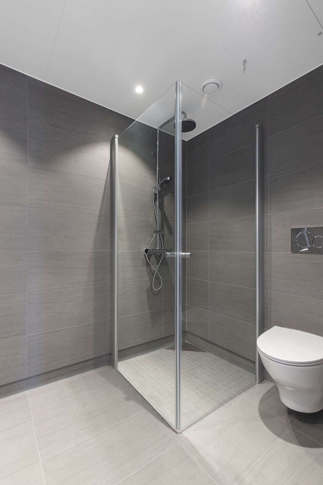 Hovedbadet er innredet med veggmontert toalett, dusjhjørne og servantinnredning med skuffer og speilskap med overlys. Badet har opplegg for vaskemaskin og tørketrommel. Galleribilde