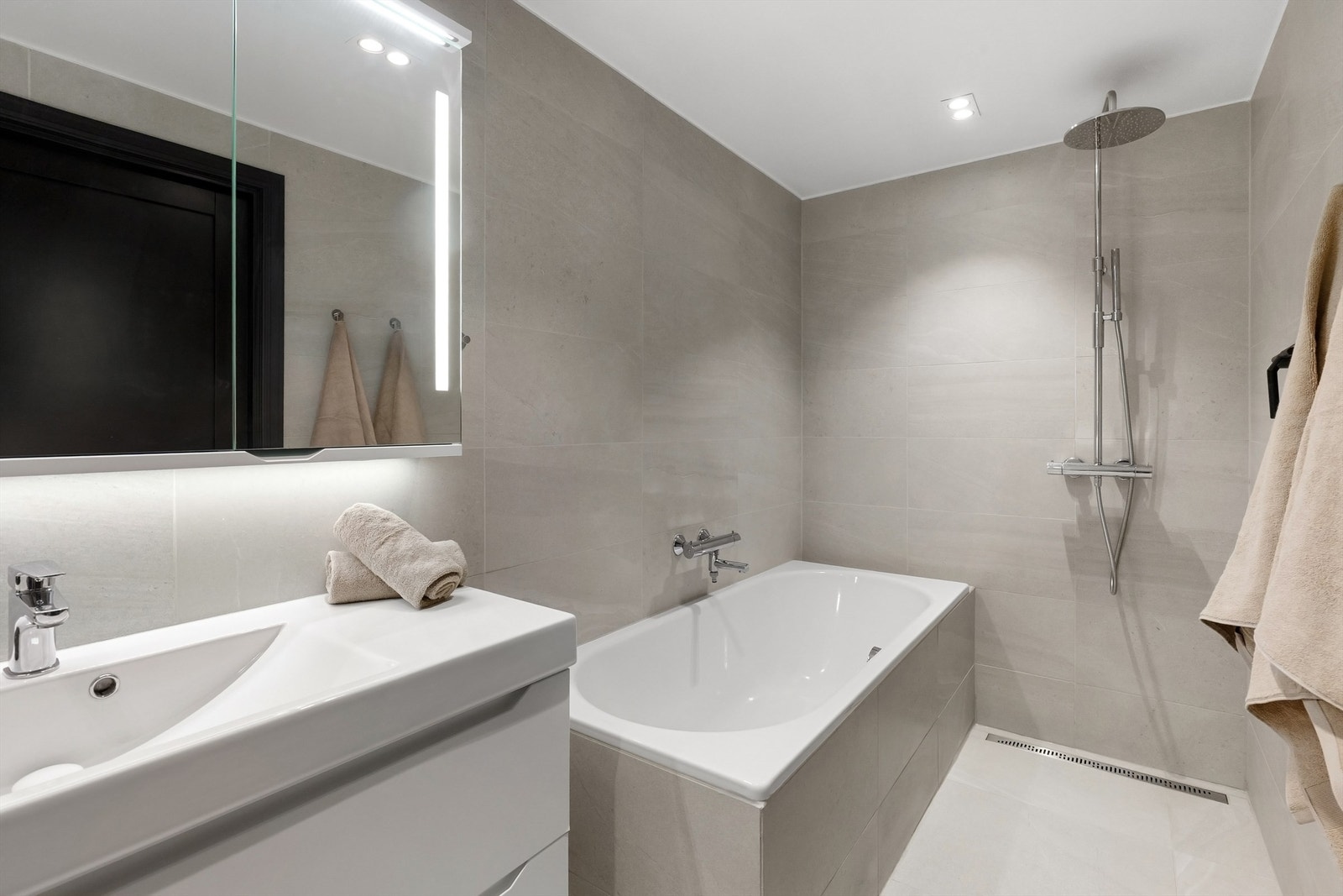 Moderne og flislagt baderom fra 2019 med gulvvarme, LED downlights i himling og regnfallsdusj Galleribilde