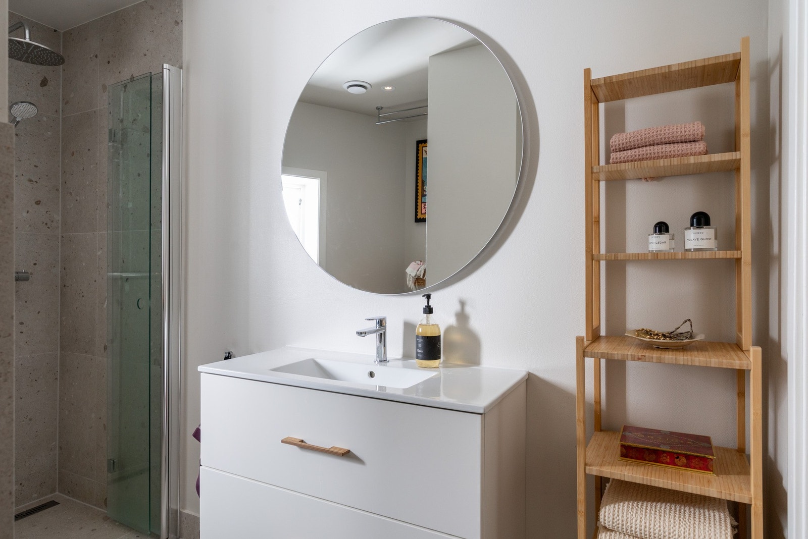 Badet er innredet med vegghengt toalett, servantskap med nedfelt servant og dusjsone. Galleribilde