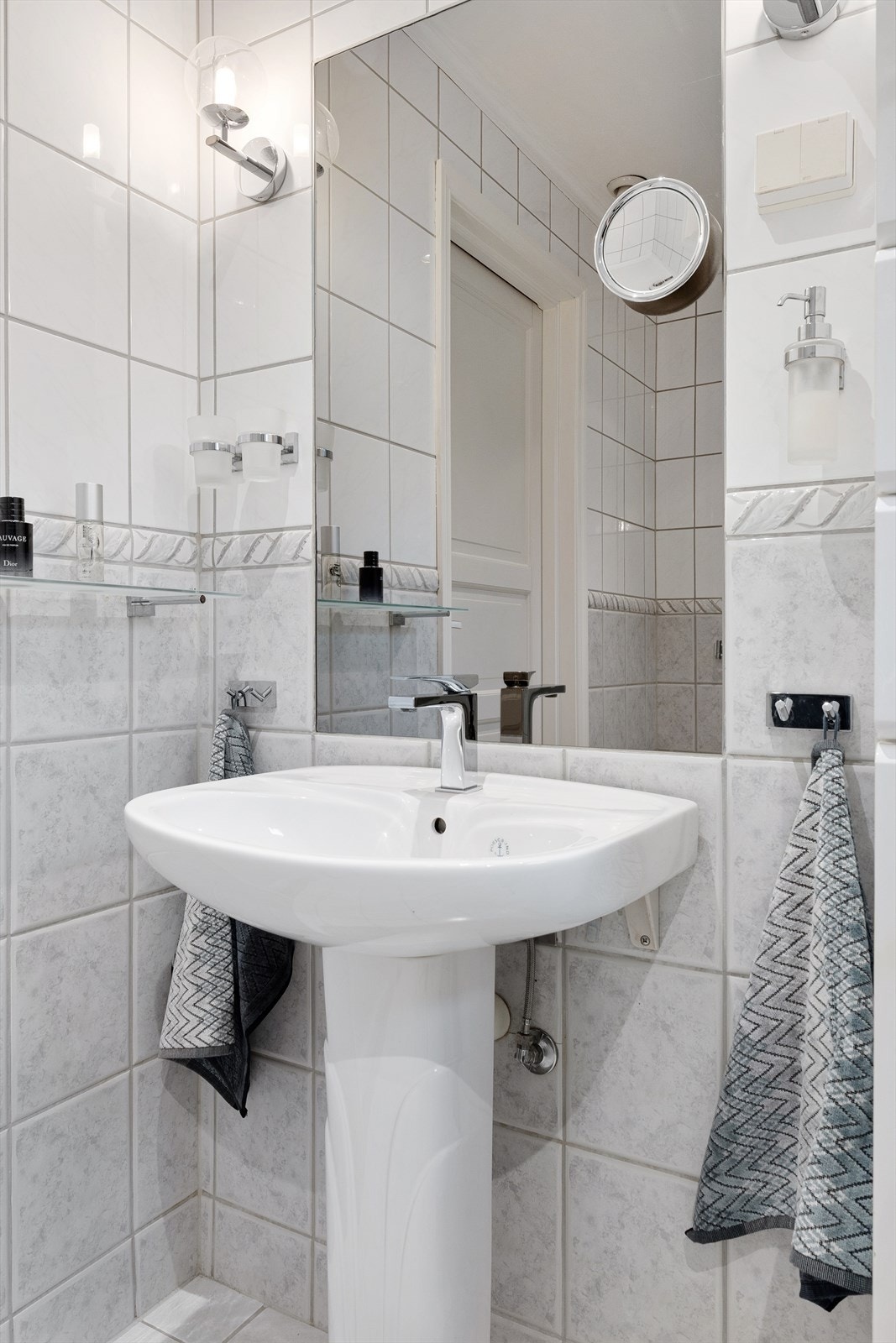 Badet er utstyrt med servant og toalett. En panelovn på veggen supplerer gulvvarmen. Galleribilde