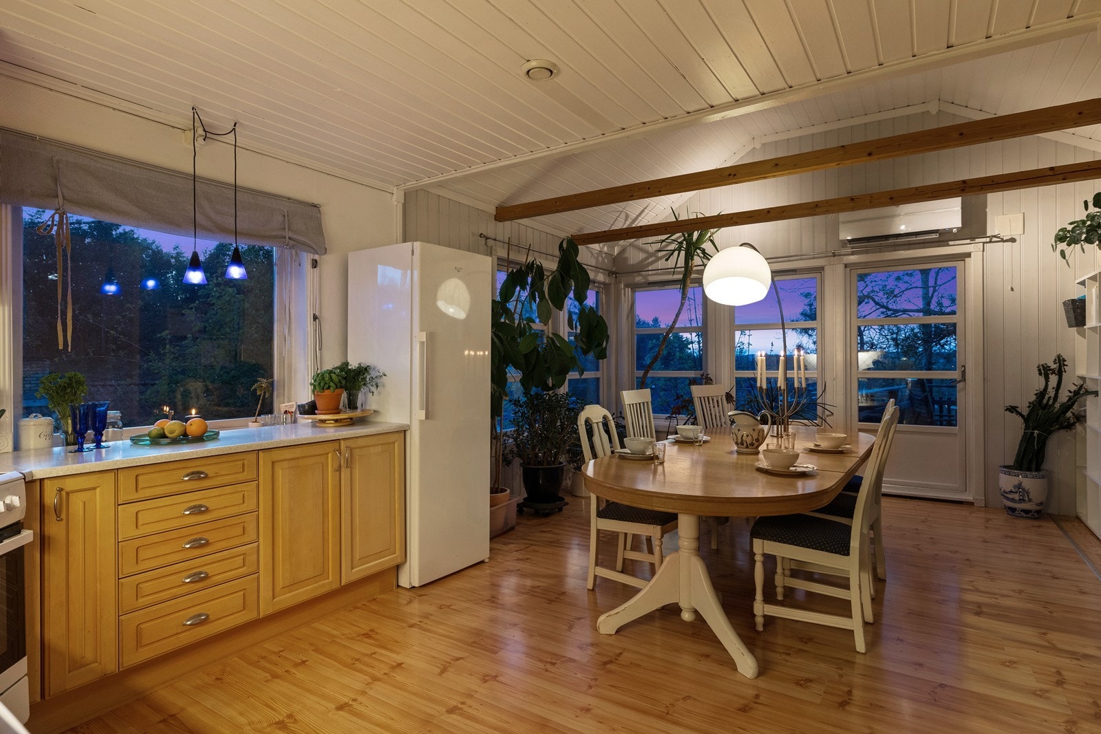 Kjøkkenet ligger i åpen forbindelse med spiseplassen og har en trivelig utforming med vinduer rundt flere sider av rommet. Her får man en fin nærhet mellom kjøkken, spiseplass og uteområde. Galleribilde