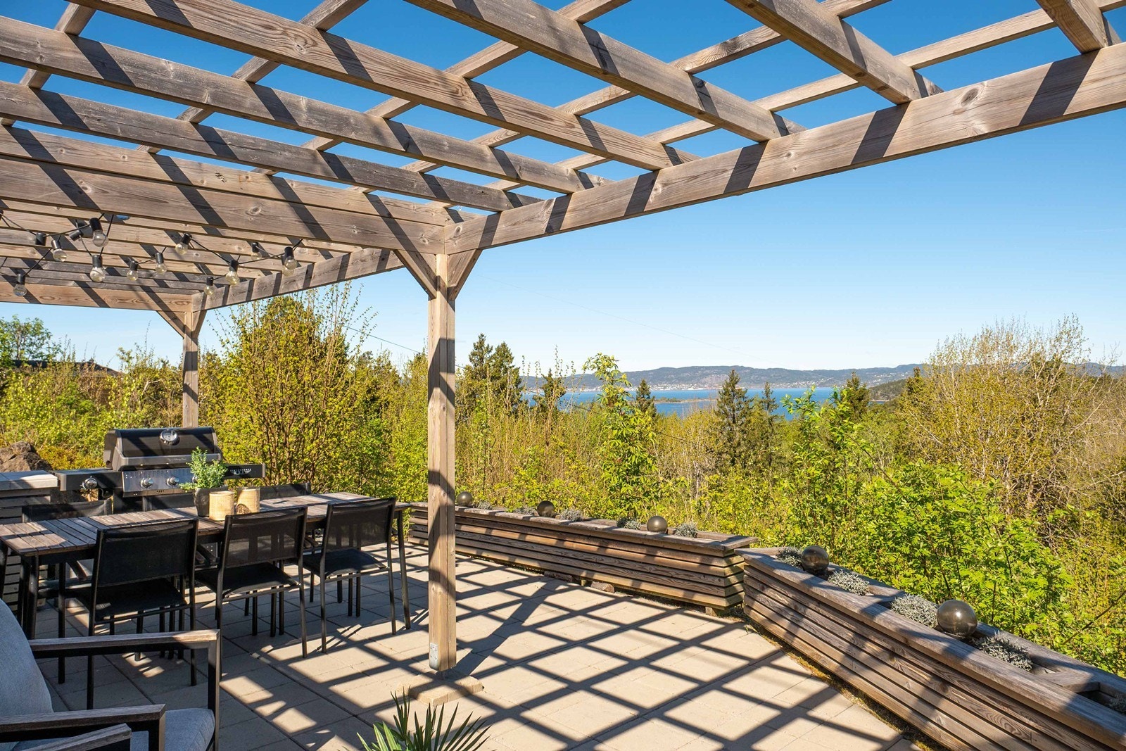 Pergola fra 2020 med spilevegger gir delvis skygge og en lun, hyggelig sone for det man måtte ønske av møblement. Galleribilde