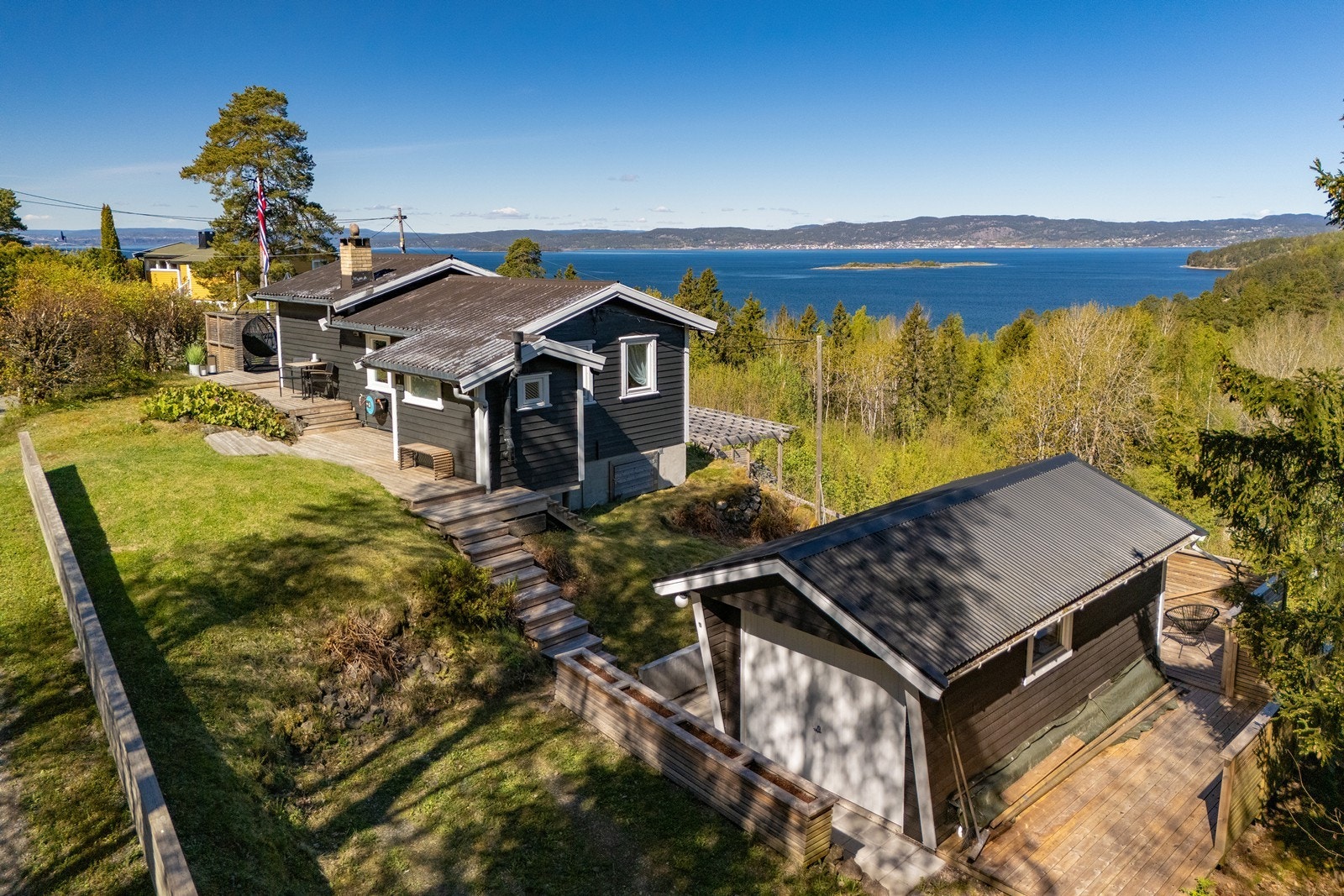 Terrassen ved hytta er pent knyttet sammen med uthus og tilhørende terrasse nord på tomten. Galleribilde
