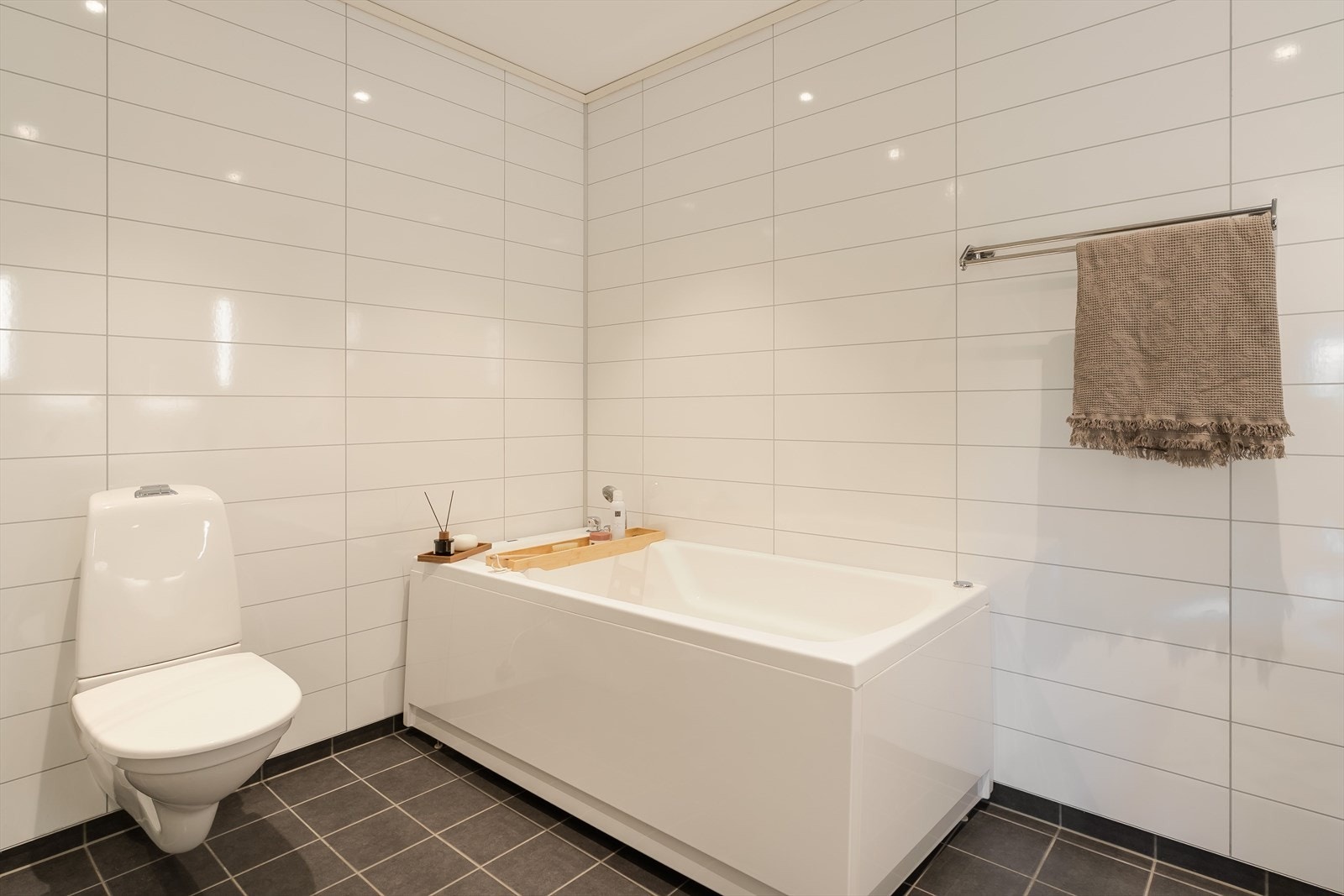 Badet er blant annet oppgradert med boblebad, større fliser på gulv, glassdør foran dusjhjørnet, Corian benkeplate og stilfullt design servantbatteri Galleribilde