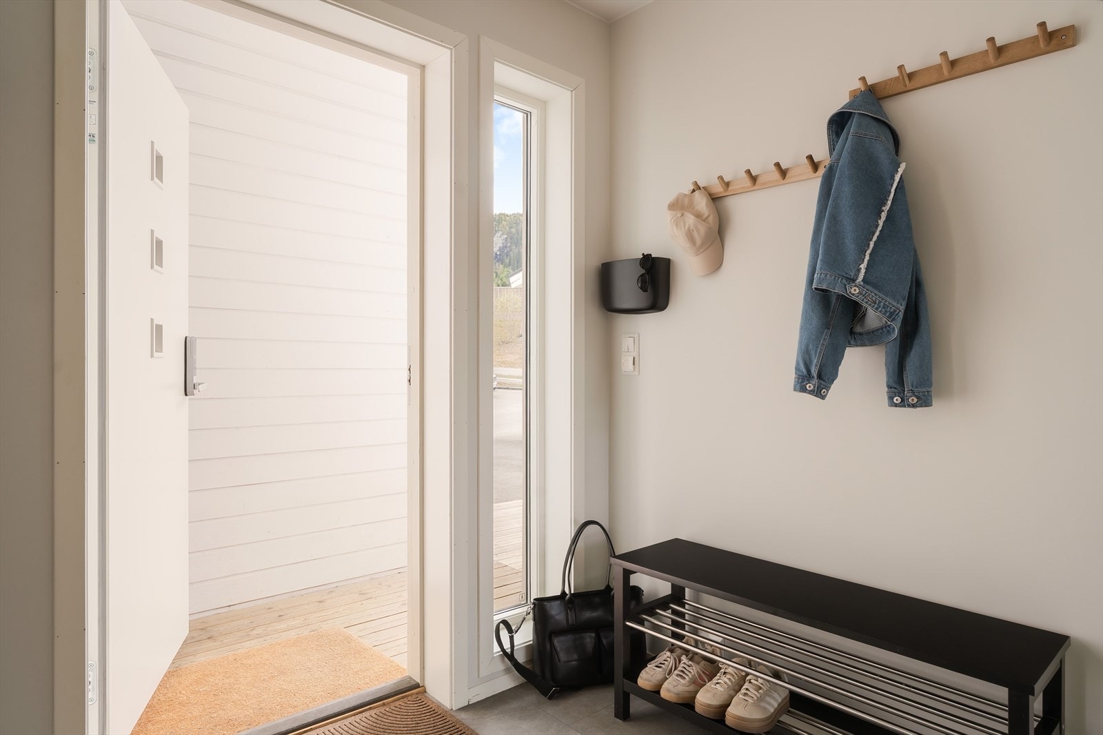 Entréen ligger praktisk til ved hovedinngangen og gir et pent førsteinntrykk av boligen. Her er det flislagt gulv, lyse vegger og god plass til sko og yttertøy. Galleribilde