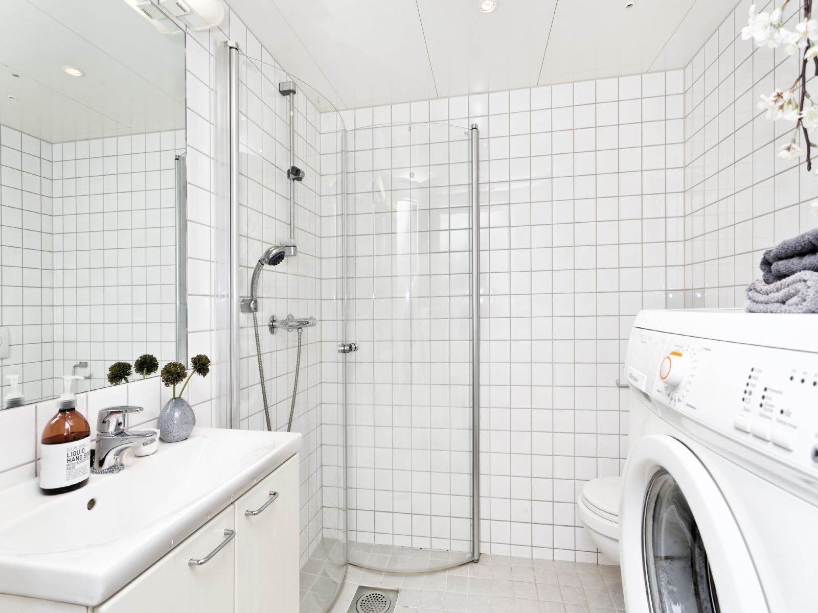 Flislagt bad med varmekabler, vegghengt wc, servantskap med oppbevaringsplass og vaskemaskin. Galleribilde