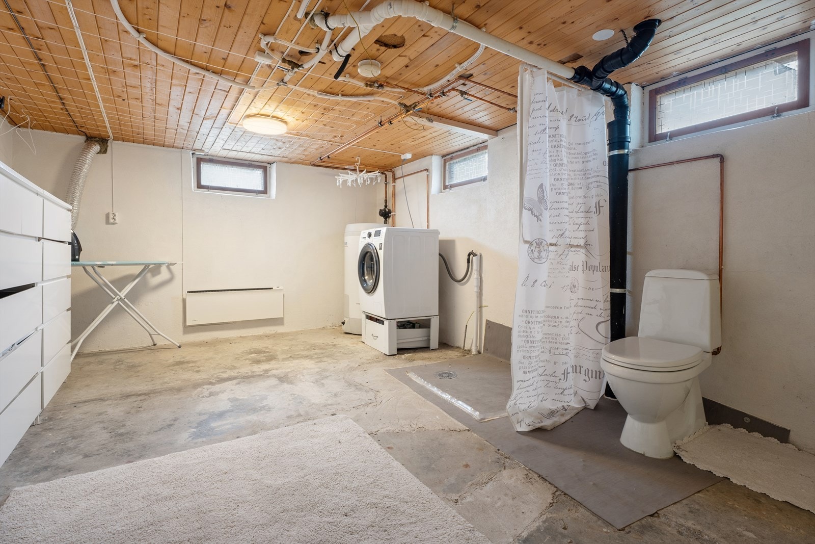 Praktisk vaskekjeller med betonggulv, opplegg for vaskemaskin og varmtvannsbereder fra 2019. Galleribilde