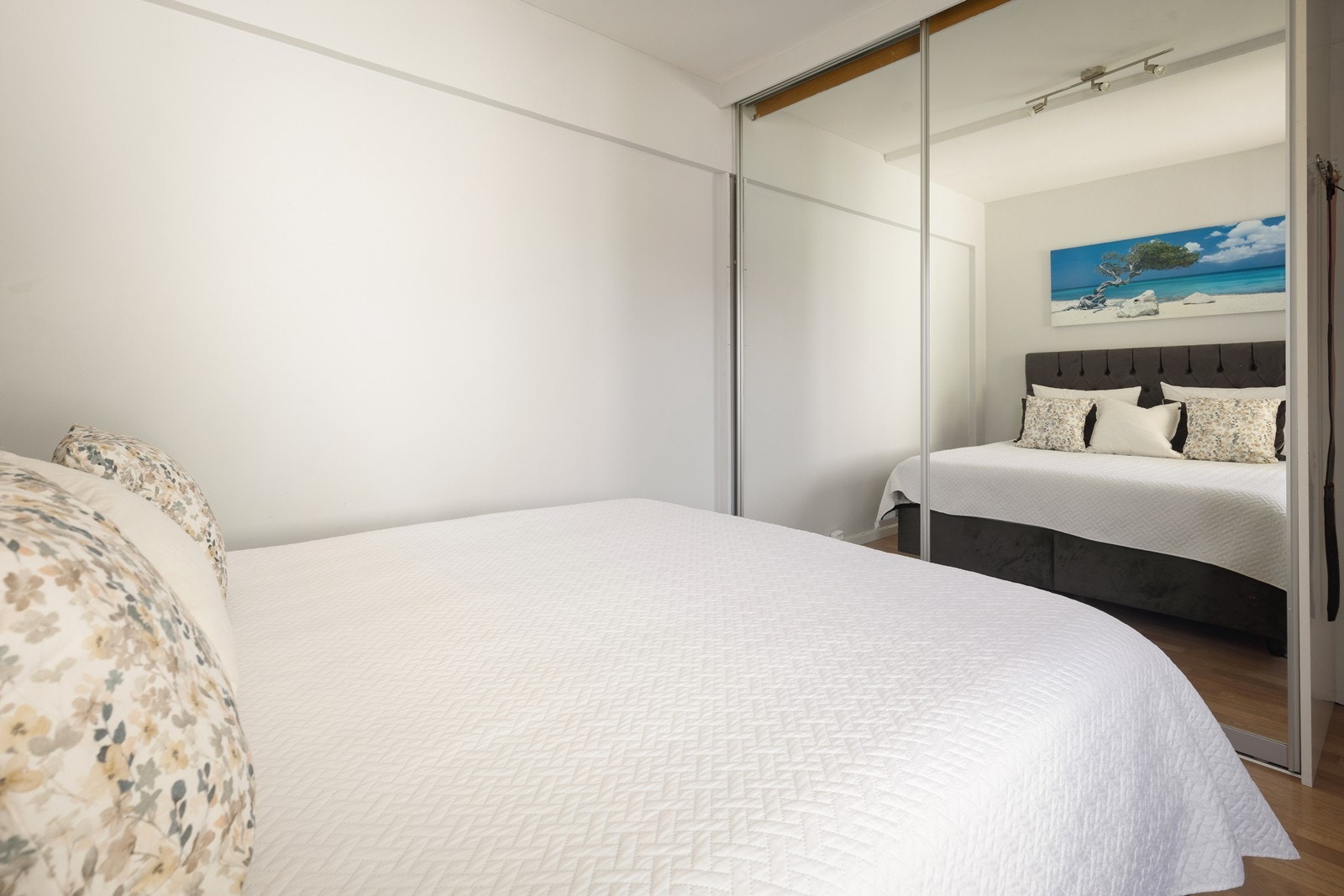 En romslig skyvedørsgarderobe med speilfronter gir rikelig med oppbevaringsplass. Galleribilde