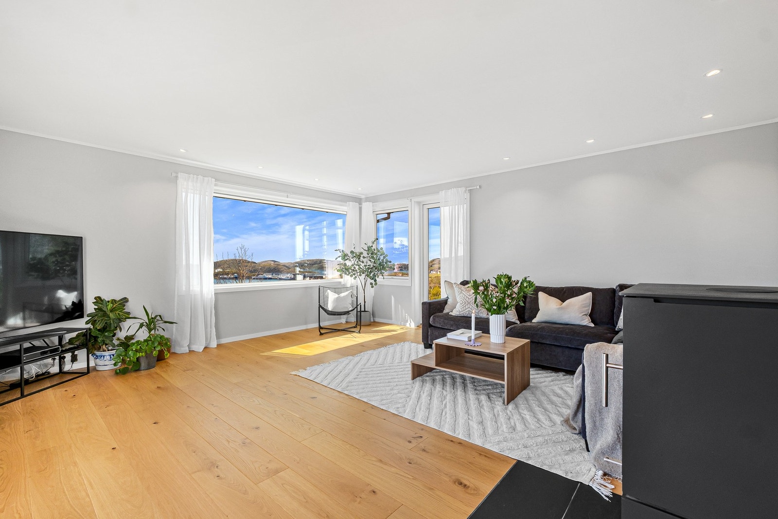 Store vindusflater gir rikelig med lys og rammer inn utsikten. Vinduene i stuen ble skiftet i 2019. Galleribilde
