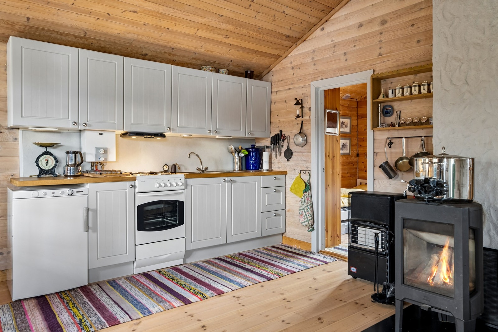 Tradisjonelle materialvalg med furugulv og panel på vegger og himlinger bidrar til en varm og innbydende atmosfære. Galleribilde