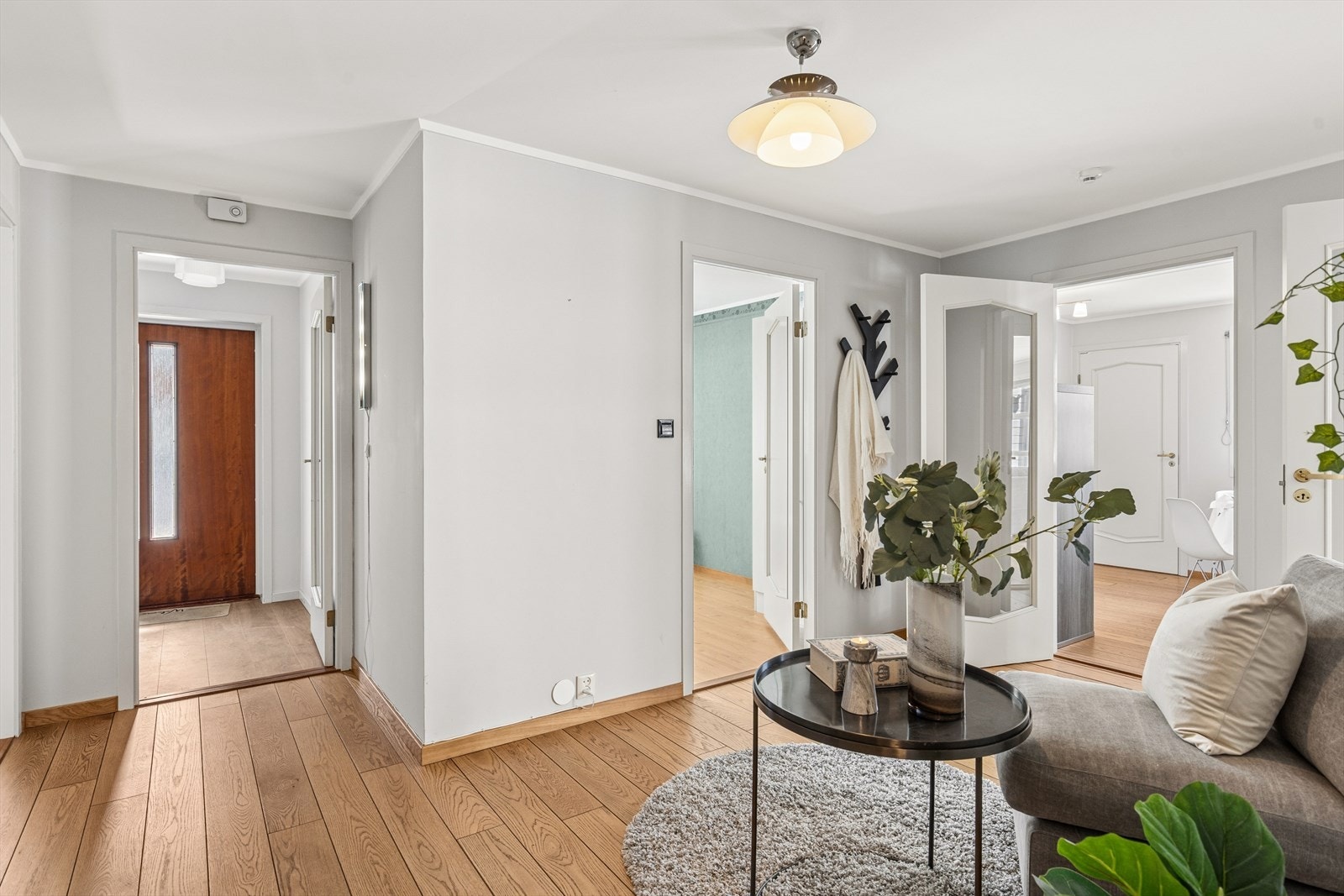 Innenfor vindfanget er det en nydelig hall med massiv eik på gulv og pene overflater - rikelig med plass for garderobe og småmøbler Galleribilde