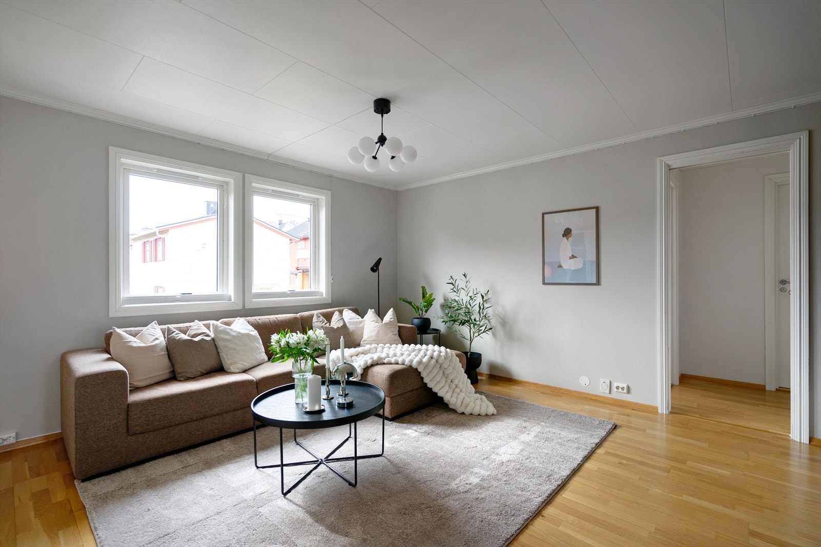 Lys og innbydende stue med store vindusflater og naturlig inndeling i hyggelige soner. Galleribilde