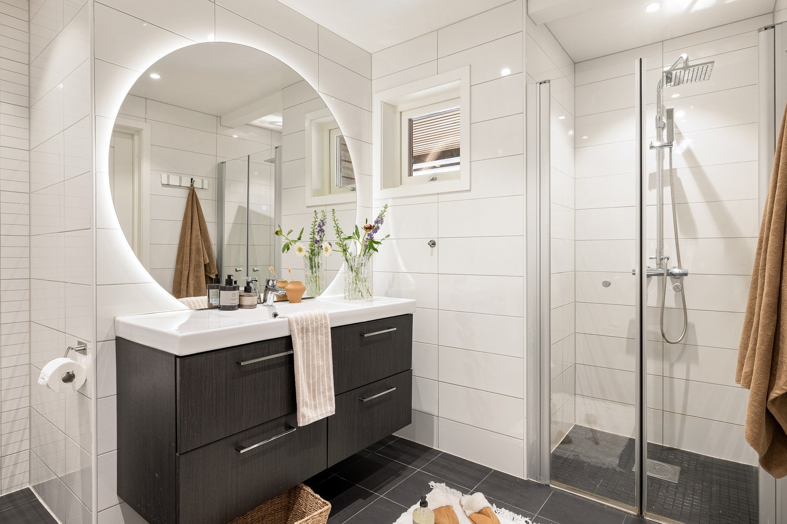 Badet har vegghengt toalett, speil med integrert lys, vask med underskap og en romslig dusj. Galleribilde