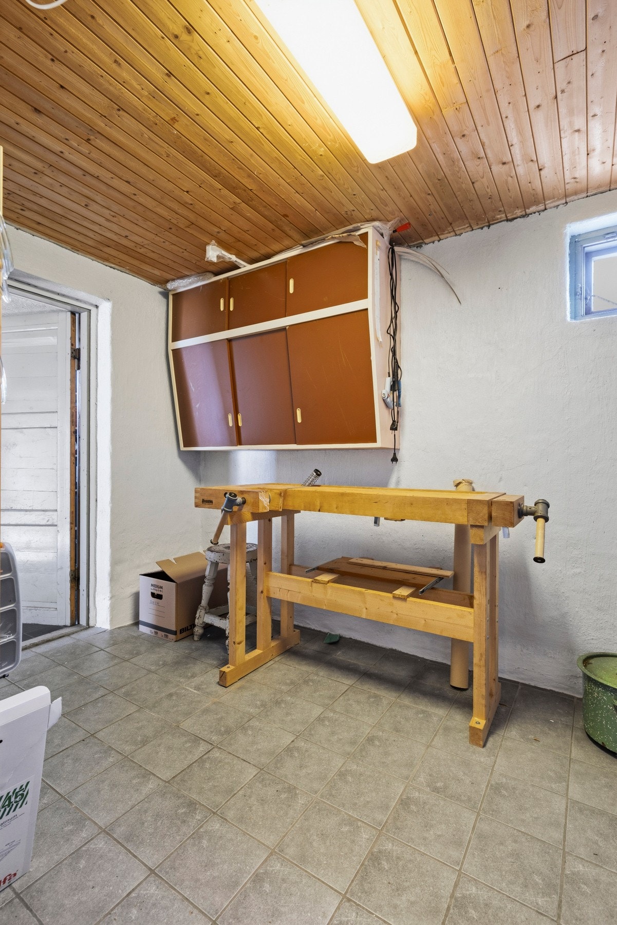 En av bodene har arbeidsbenk og oppbevaringsskap Galleribilde