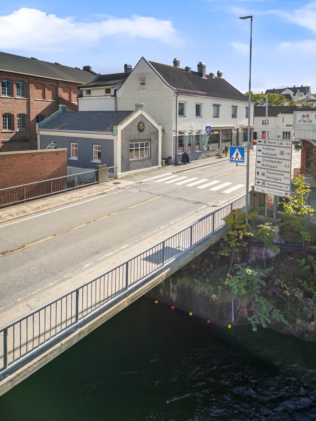 Skilting viser kort vei til lokale attraksjoner som Kunstlåven, Fossesholm Herregård og Strandajordet. Galleribilde