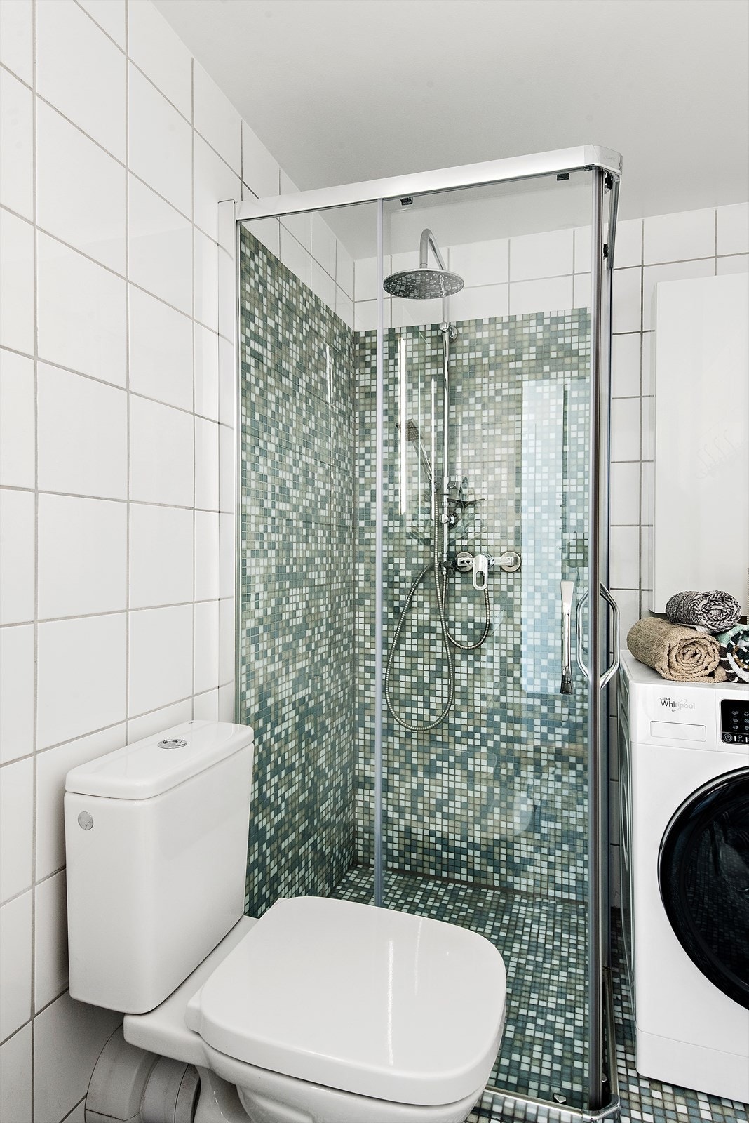 Badet har et dusjhjørne med glassdører og avtrekksventil i himlingen. Galleribilde