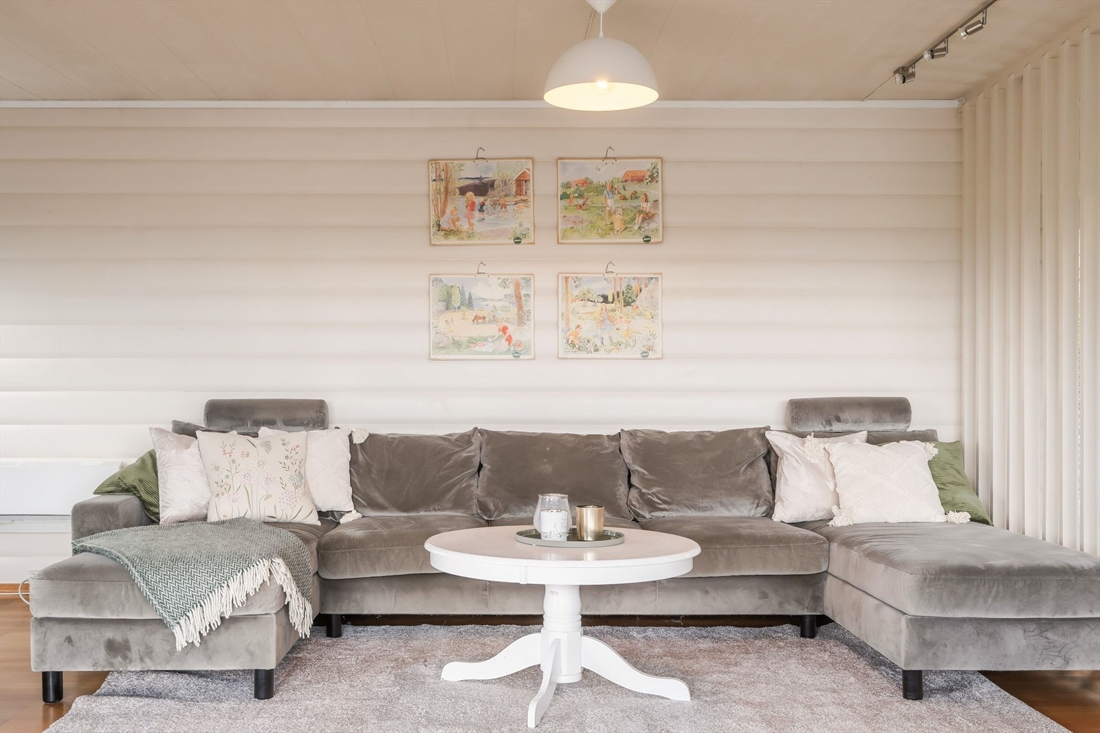 Her er rommet delt inn på en praktisk måte, med en hyggelig sofakrok på den ene siden og en stor spisestuesone vendt mot vindusflatene på den andre. Galleribilde
