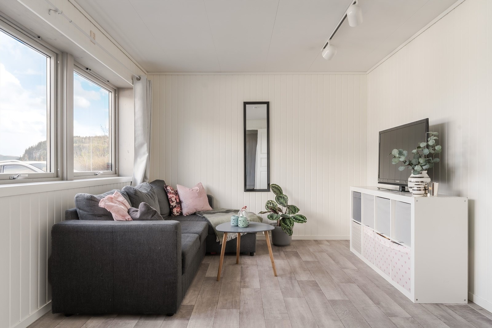 Kjellerstuen er et lyst og trivelig rom med store vinduer, lyse panelvegger og gulv i moderne trestruktur. Rommet er enkelt å møblere med sofagruppe, TV-løsning og oppbevaring, og fungerer godt som en ekstra oppholdssone for familien. Galleribilde