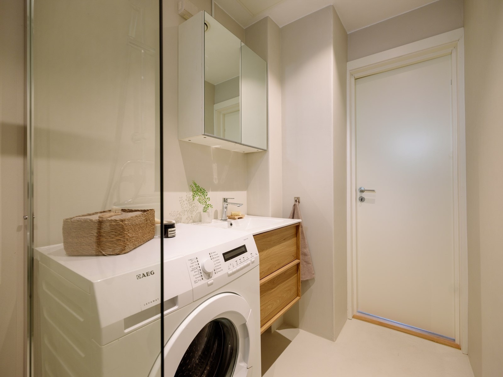 Badet har gulvvarme og er utstyrt med dusjhjørne med fastmontert glassvegg, blandebatteri med regndusj og håndholdt dusjslange samt opplegg for vaskemaskin. Galleribilde