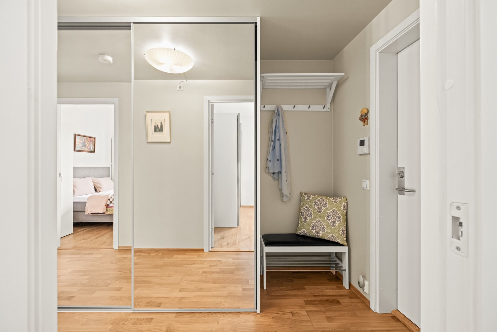 Her er det god plass til å henge fra seg yttertøy og sko i praktisk skyvedørsgarderobe, noe som bidrar til et ryddig og stilrent uttrykk i hverdagen. Galleribilde