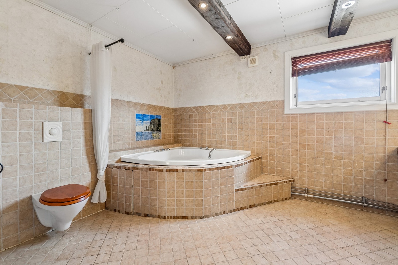 Det ene badet har hjørnebadekar, vegghengt toalett, egen dusjsone og badstue. Galleribilde
