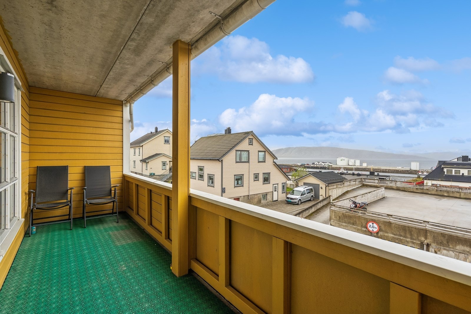 Utsikten fra verandaen. Praktisk uteareal med takoverbygg og naturlig le for vinden ved at verandaen er bygd inn i fasaden. Galleribilde