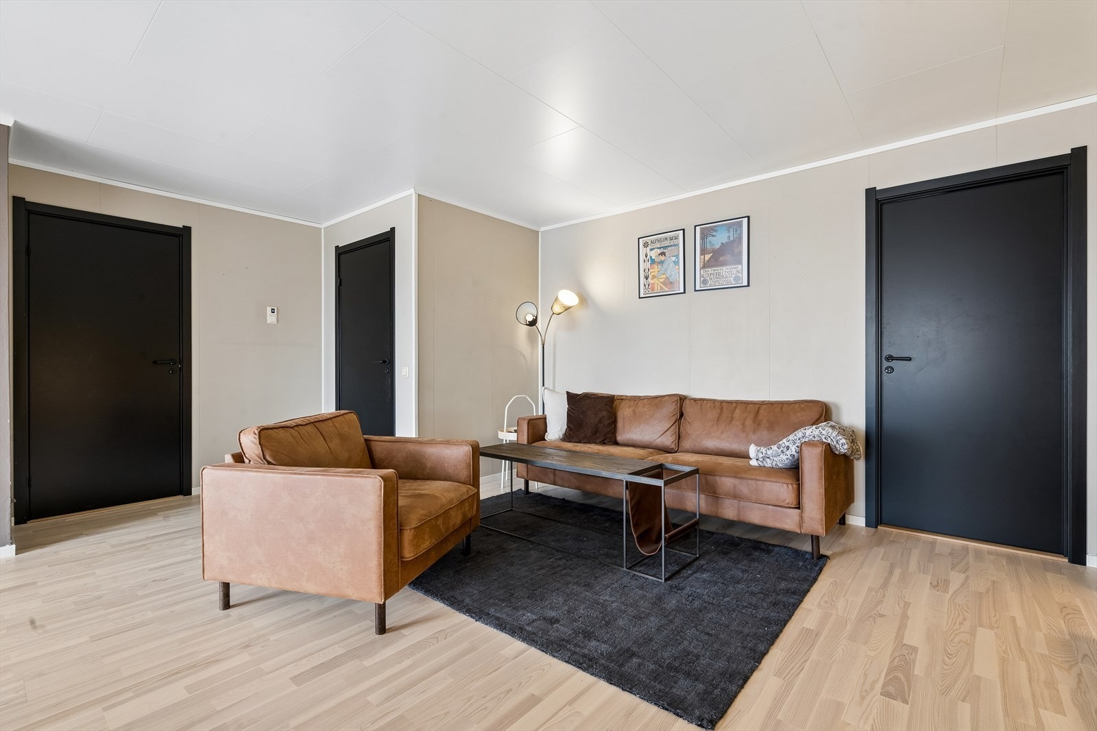 De store vinduene slipper inn godt med lys. Dørene er i moderne matt utførelse i svart farge. På bildet ser man adkomsten til soverom, gang og bod. Galleribilde
