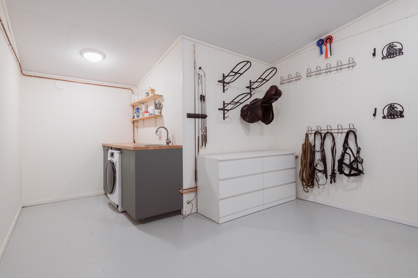 I stallen er det eget varme-/oppholds-/salrom. Utstyrt med både varmekabler i gulv, opplegg for vaskemaskin, vask med både varmt og kaldt vann. Galleribilde