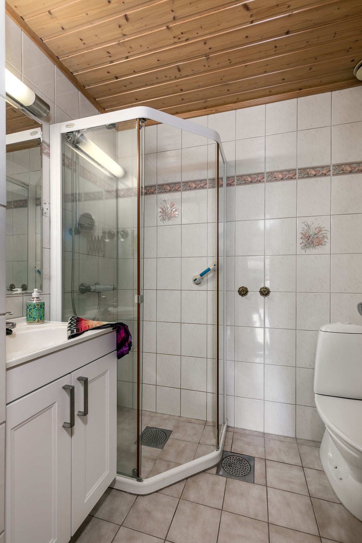 Flislagt bad med varmekabler, servantinnredning, toalett og dusjløsning med skyvedører. Badet er oppgradert etter byggeår og fremstår med en funksjonell planløsning. Galleribilde